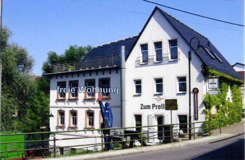 un grand bâtiment blanc sur le côté d'une rue dans l'établissement Ferienwohnung Lehmann, à Lunzenau