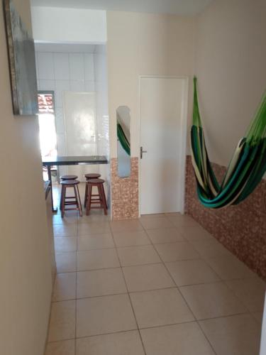 a room with a table and chairs and a hammock at Casa Larithur in Beberibe