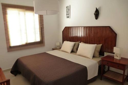a bedroom with a large bed with a wooden headboard at El Pasadizo - The secret passage-Puerto del Carmen in Puerto del Carmen