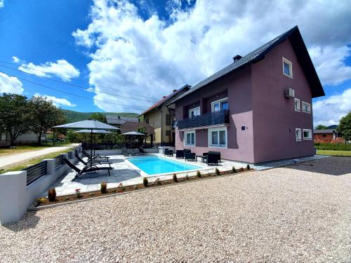 a house with a swimming pool in front of it at Premier House by RD Group in Korenica