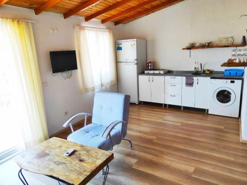 ein Wohnzimmer mit einem Tisch und einer Küche in der Unterkunft Likya SUP Apart in Kaş