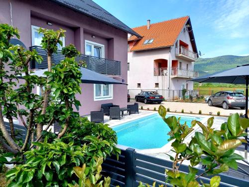 a swimming pool in front of a house at Premier House by RD Group in Korenica