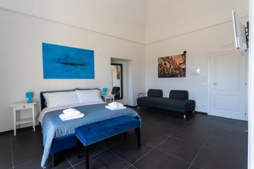 a bedroom with a bed and a couch at Bed and Breakfast Terra del Sole Ibla in Ragusa