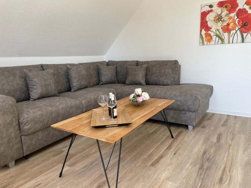 a living room with a couch and a table with wine glasses at Haus Nordseekrabbe in Greetsiel