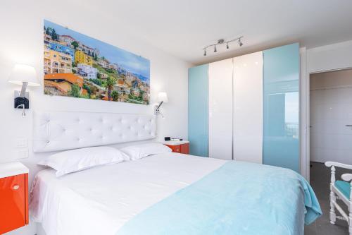 une chambre avec un lit blanc et un tableau au mur dans l'établissement Au Soleil de Nice, à Nice