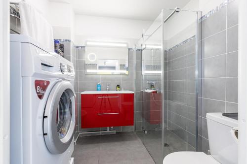 La salle de bains est pourvue d'un lave-linge et d'une armoire rouge. dans l'établissement Au Soleil de Nice, à Nice