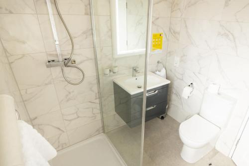 a bathroom with a shower and a toilet and a sink at Station House Bed & Breakfast in Ennistymon