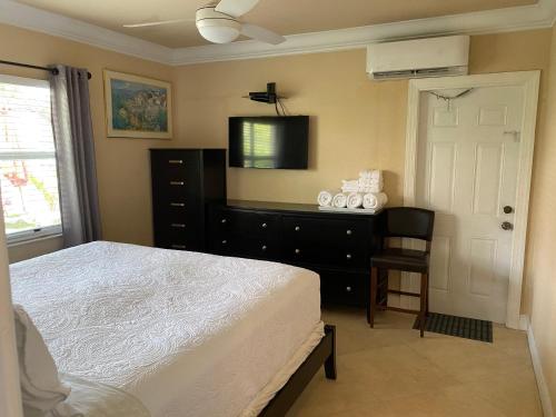 a bedroom with a bed and a dresser and a television at Atlantic Shores Vacation Villas in Palm Beach Shores