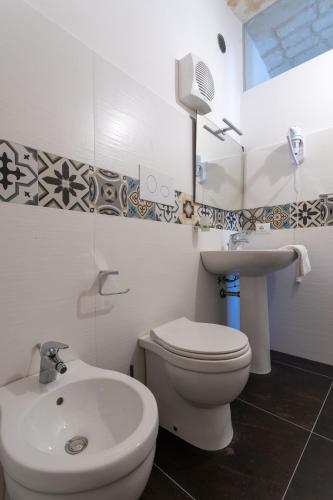 a bathroom with a white toilet and a sink at Bed and Breakfast Terra del Sole Ibla in Ragusa