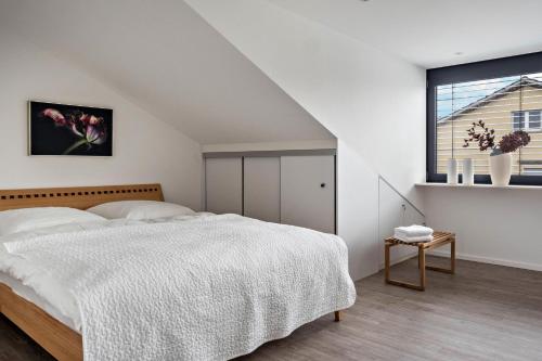 ein weißes Schlafzimmer mit einem Bett und einem Fenster in der Unterkunft Ferienwohnung Rosenrot am See in Konstanz