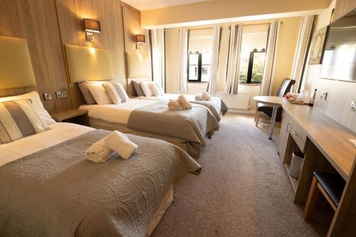 a hotel room with three beds with towels on them at Station House Bed & Breakfast in Ennistymon