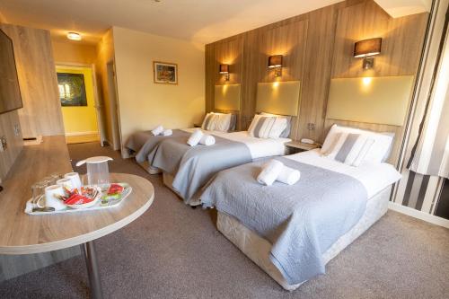 a hotel room with two beds and a table at Station House Bed & Breakfast in Ennistymon