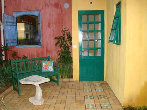 a green door and a bench in front of a building at Villa do Arquiteto in Nova Petrópolis