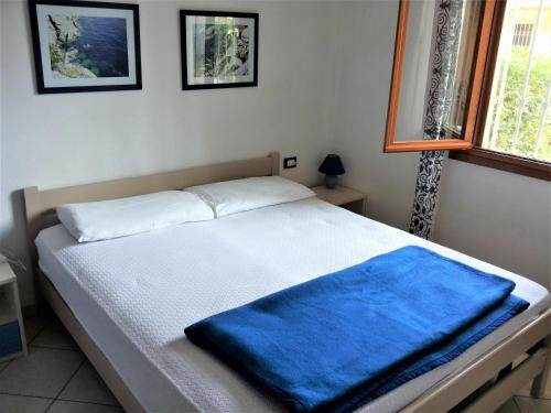 a bedroom with a bed with a blue blanket on it at Azzurro in Bibione