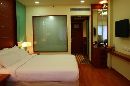 a hotel room with a bed and a television at Ramoji Film City- Tara Comfort Hotel in Pedda Ambarpet
