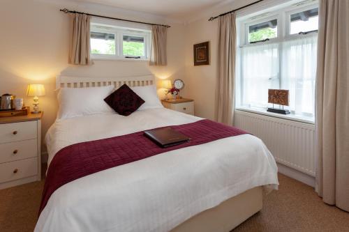 a bedroom with a bed with a book on it at Avalon House B&B in Lyndhurst