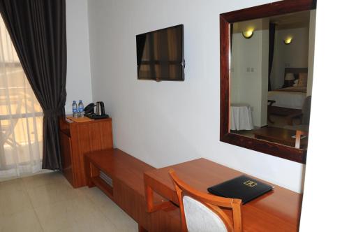 a room with a desk and a mirror and a table at Royal Palace Hotel in Juba