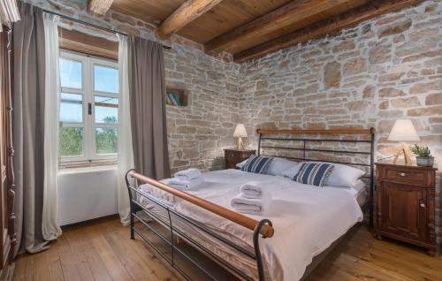 une chambre avec un lit et un mur de briques dans l'établissement Family Villa Kata San Lorenzo, à Vošteni