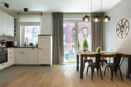 a kitchen and dining room with a table and chairs at Zentrum II Apartament IMPERO z Parkingiem in Poznań