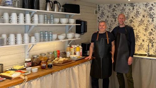 two men standing next to a counter in a kitchen at Peppinge Bed & Breakfast in Löderup