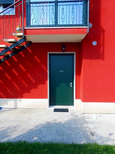 a red building with a green door and a balcony at VCE House in Tessera