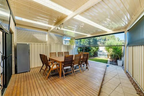 a dining room with a table and chairs on a deck at Swainson on 1 Lexington - 200m to Beach! in Henley Beach