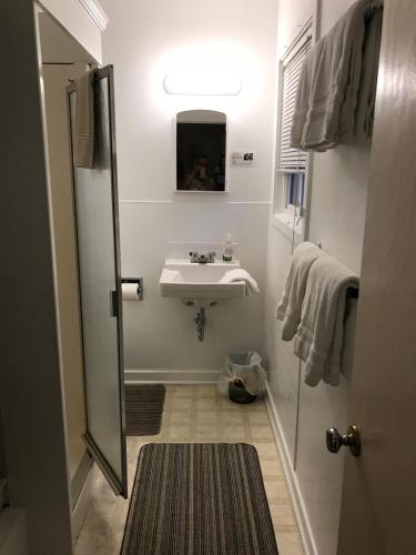 Baño blanco con lavabo y espejo en Holiday Lodge Cabins, en Banff