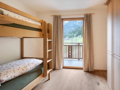 sypialnia z łóżkiem piętrowym i dużym oknem w obiekcie Radlspitz Maurerhof w mieście Valdurna