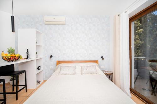 a bedroom with a bed and a desk and a window at Apartment IVA Studio in Rabac