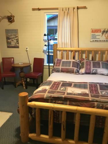a bed room with a bed and a desk at Holiday Lodge Cabins in Banff