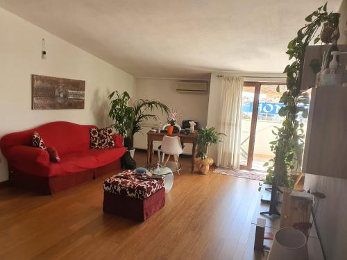 sala de estar con sofá rojo y mesa en b&b La terrazza, en Assemini