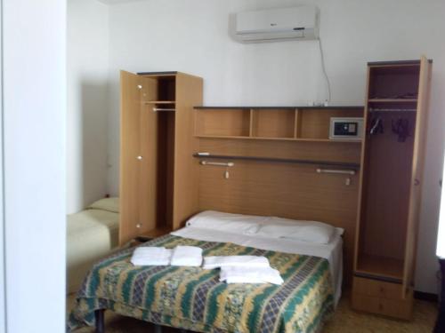 ein kleines Zimmer mit einem Bett mit Handtüchern darauf in der Unterkunft Hotel Gino in Noli