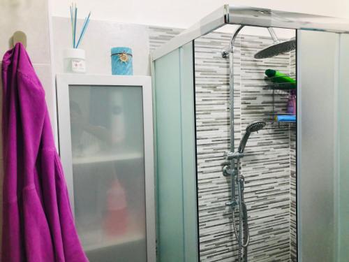 La salle de bains est pourvue d'une douche avec une porte en verre. dans l'établissement La casa di Palma, à Catane