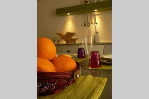 a basket of oranges on a table in a kitchen at L'Approdo Bilocale in Carloforte