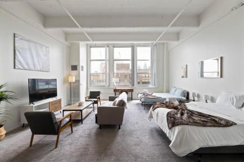 a bedroom with two beds and a living room at Loft640 in Center City w Parking, Pool, Gym in Philadelphia