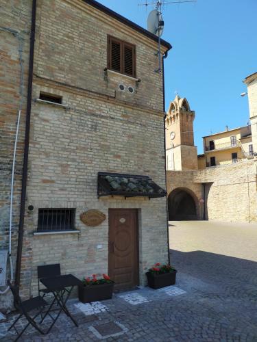 a brick building with a door and a clock tower at B&B casa vacanze LA DIMORA DI MADDALENA in Tortoreto Lido