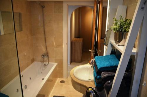 a bathroom with a tub and a toilet and a sink at Penthouse mit privatem Jacuzzi in Marbella - La Mairena in Ojén