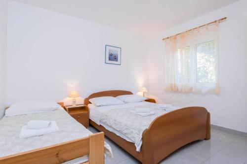 1 Schlafzimmer mit 2 Betten und einem Fenster in der Unterkunft Apartment in Orebic with terrace, air conditioning, WiFi, washing machine (4934-3) in Orebić