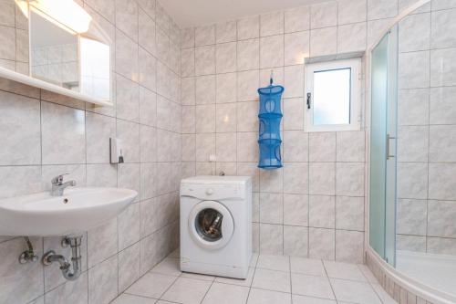 ein Badezimmer mit einer Waschmaschine und einem Waschbecken in der Unterkunft Apartment in Orebic with terrace, air conditioning, WiFi, washing machine (4934-3) in Orebić