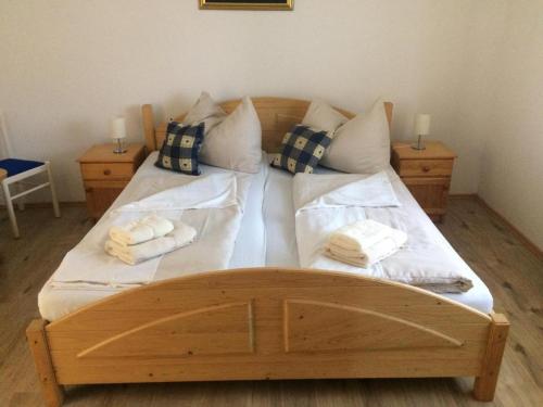 a large wooden bed with two towels on it at Báró Berg Apartman2 in Kapuvár