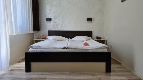 a bedroom with a bed with white sheets and pillows at Hotel Royal Drina in Mali Zvornik
