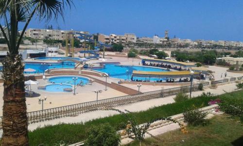 un groupe de piscines dans un parc avec des bâtiments dans l'établissement Roof 2 Bedrooms sea view Green Beach 150, à El Alamein