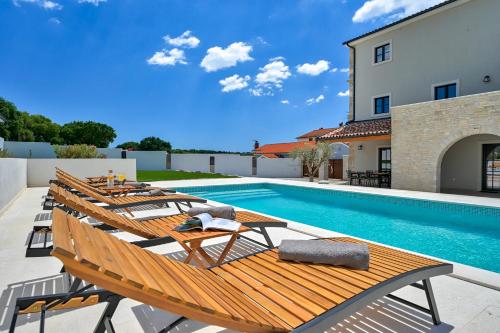 a pool with a bunch of chairs and a swimming pool at Villa Vitassi in Pula