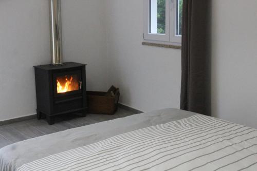 a bedroom with a bed and a stove in a room at Casinhas da Lu in Geres