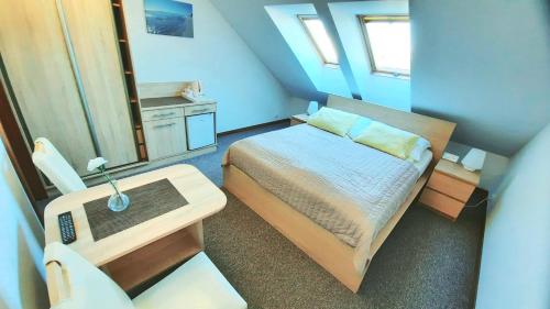 a small bedroom with a bed and a table at Morska Fala in Jastarnia