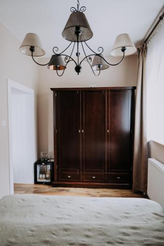 a bedroom with a large wooden cabinet and a chandelier at Willa Sepia SPA in Wisła
