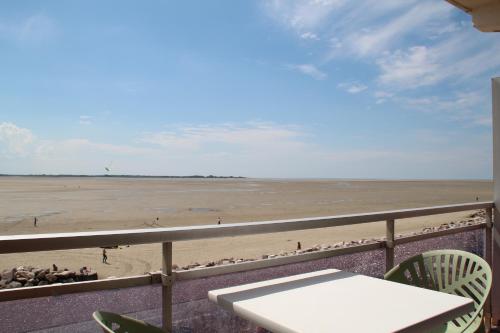 - une vue sur la plage dotée d'une table et de chaises dans l'établissement Coucher du Soleil, au Crotoy