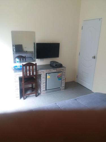 a living room with a television and a chair at Boat house marina restaraunt and homestay in Suratthani