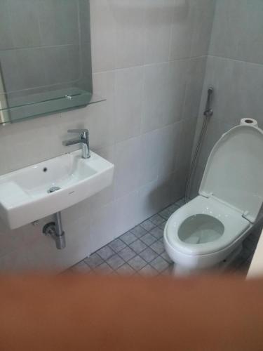 un baño con inodoro y lavabo en Boat house marina restaraunt and homestay, en Suratthani