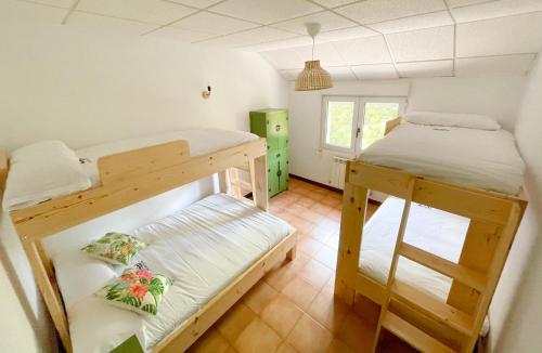 a room with two bunk beds and a window at Arena Surf Hotel in Somo